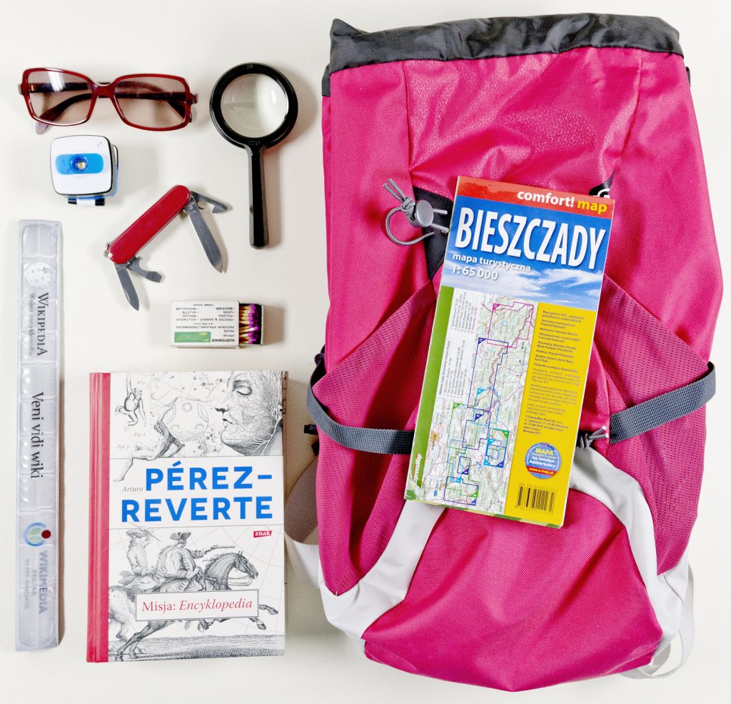 Plecak, mapa,, książka, lupa, okulary przeciwsłoneczne, scyzoryk szwajcarsk, zapałki, kompas, linijka