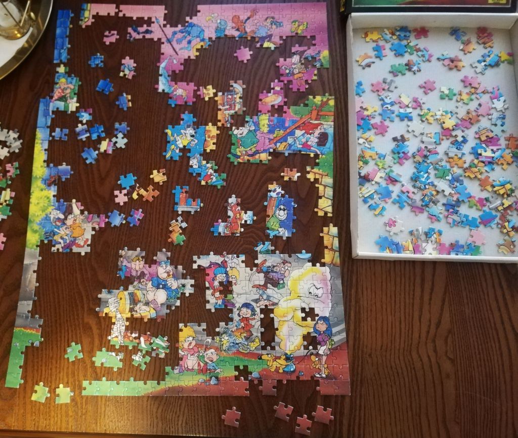 Zdjęcie stołu na którym są układane kolorowe puzzle.