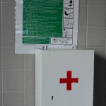 Apteczka oraz plakat informujący o udzielaniu pierwszej pomocy w aneksie jadalnym dla pracowników BUW na poziomie 2.