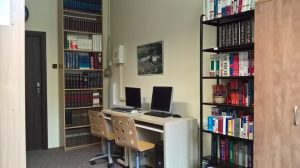wnętrze pokoju, biurko, dwa komputery, dwa regały z książkami
