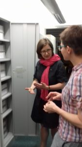 archiwistka i bibliotekarka rzed szafą z dokumentami