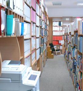 Regały z książkami oraz ksero w czytelni Biblioteki Centrum Europejskiego UW