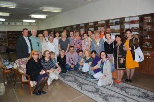 Zdjęcie grupy uczestników wycieczki w Bibliotece Miejskiej w Bucharze. Osoby są ustawione w trzech rzędach półkolem, pierwszy rząd przykucnął.