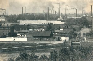 Zdjęcie przedstawiające panoramę dzielnicy przemysłowej, z wszechobecnymi kominami.