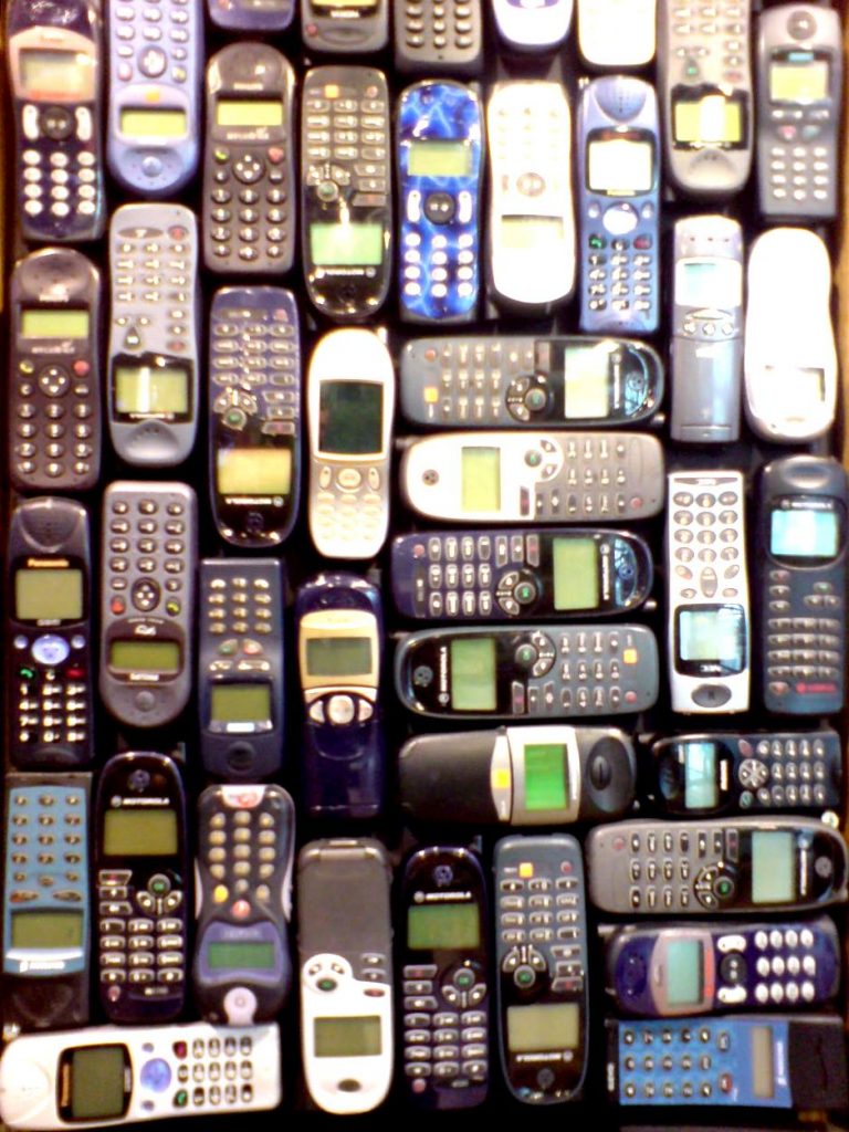 Zdjęcie starych telefonów komórkowych (z klawiaturą i monochromatycznymi wyświetlaczami) ułożonych jeden przy drugim w swego rodzaju mozaikę.