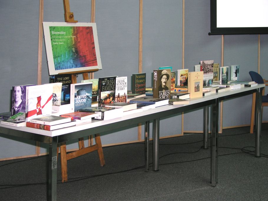 Zdjęcie stołu z książkami w jezyku angielskim. W tle plakat Bloomsday