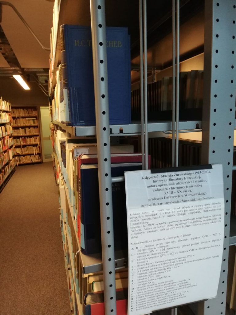 Zdjęcie regałów z książkami, a pierwszym planie informacja o księgozbiorze.