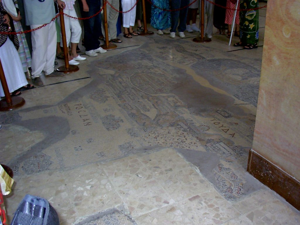 Ludzie stojący wokół starożytnej mozaiki.