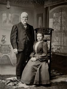 Pozowane zdjęcie stojącego mężczyzny i siedzącej kobiety