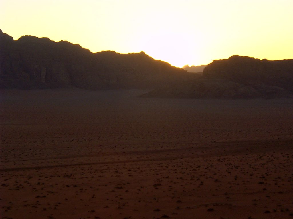 zachodzące słońce na skałami i pustynią
