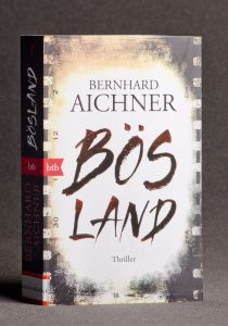Napis "Bösland" na tle starej taśmy filmowej