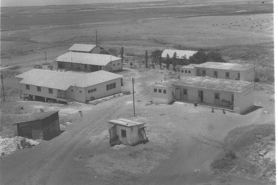 Czarno-białe zdjęcie parterowych budynków na pustyni.