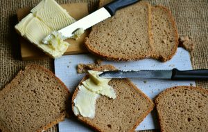 Zdjęcie kromek chleba dwóch noży i masła.