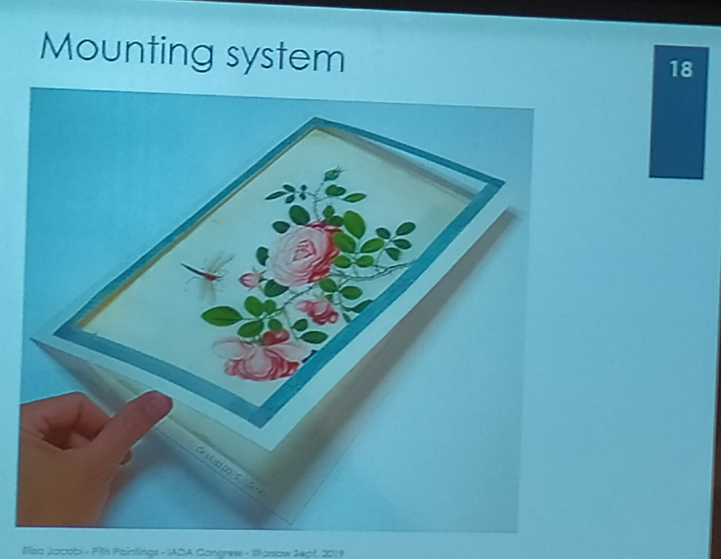 Karta pith painting po konserwacji przedstawia kompozycję kwiatową w ramie