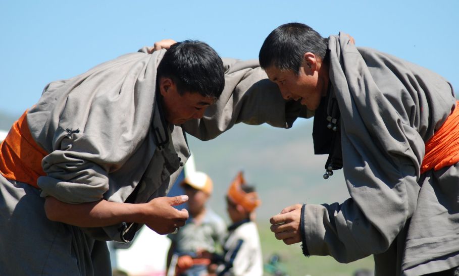 Dwóch mongolskich zapaśników ubranych w szare stroje.