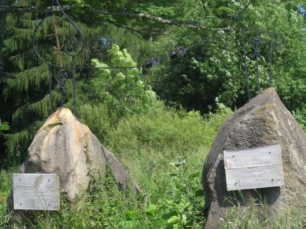 zdjęcie dwóch głazów z tablicami pamiątkowymi na tle lasu.