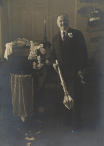 Zdjęcie mężczyzny w garniturze trzymającego buławę.
