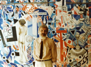 Zdjęcie Zbigniewa Makowskiego na tle artystycznie pomalowanej kształtami geometrycznymi ściany.