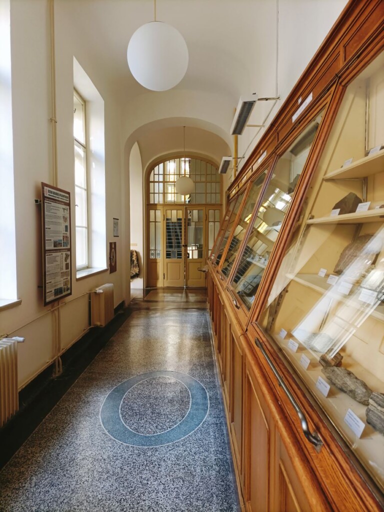 zdjęcie korytarza po prawej stronie gabloty z kamieniami na półkach.