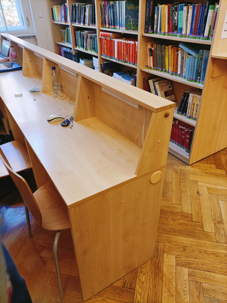 drewniane biurka i regały z książkami