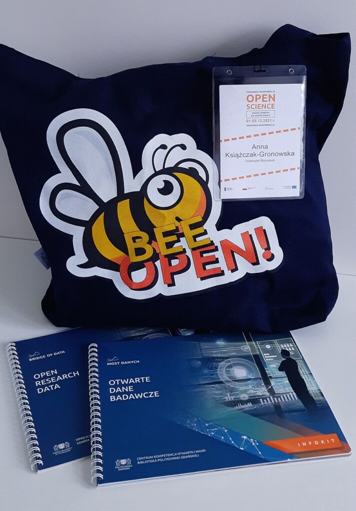 Zdjęcie pakietu konferencyjnego, na nim torba, identyfikator i materiały konferencyjne.
