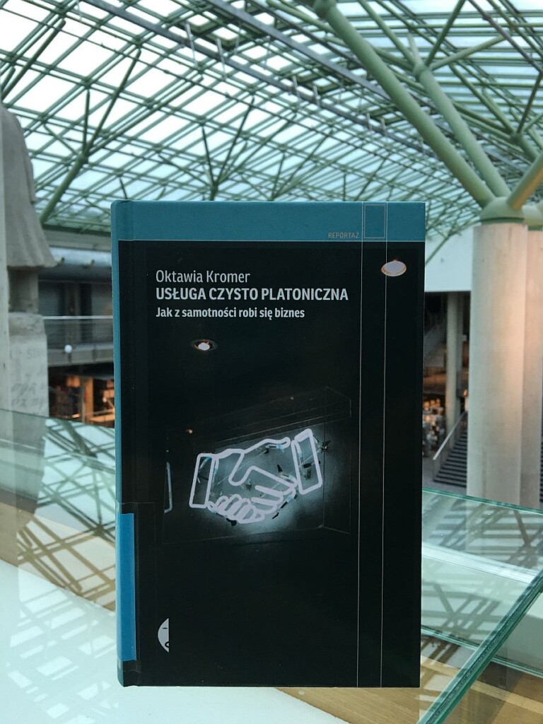 Zdjęcie okładki książki Usługa czysto platoniczna, na niej zdjęcie neonu przedstawiającego dłonie w powitalnym uścisku.