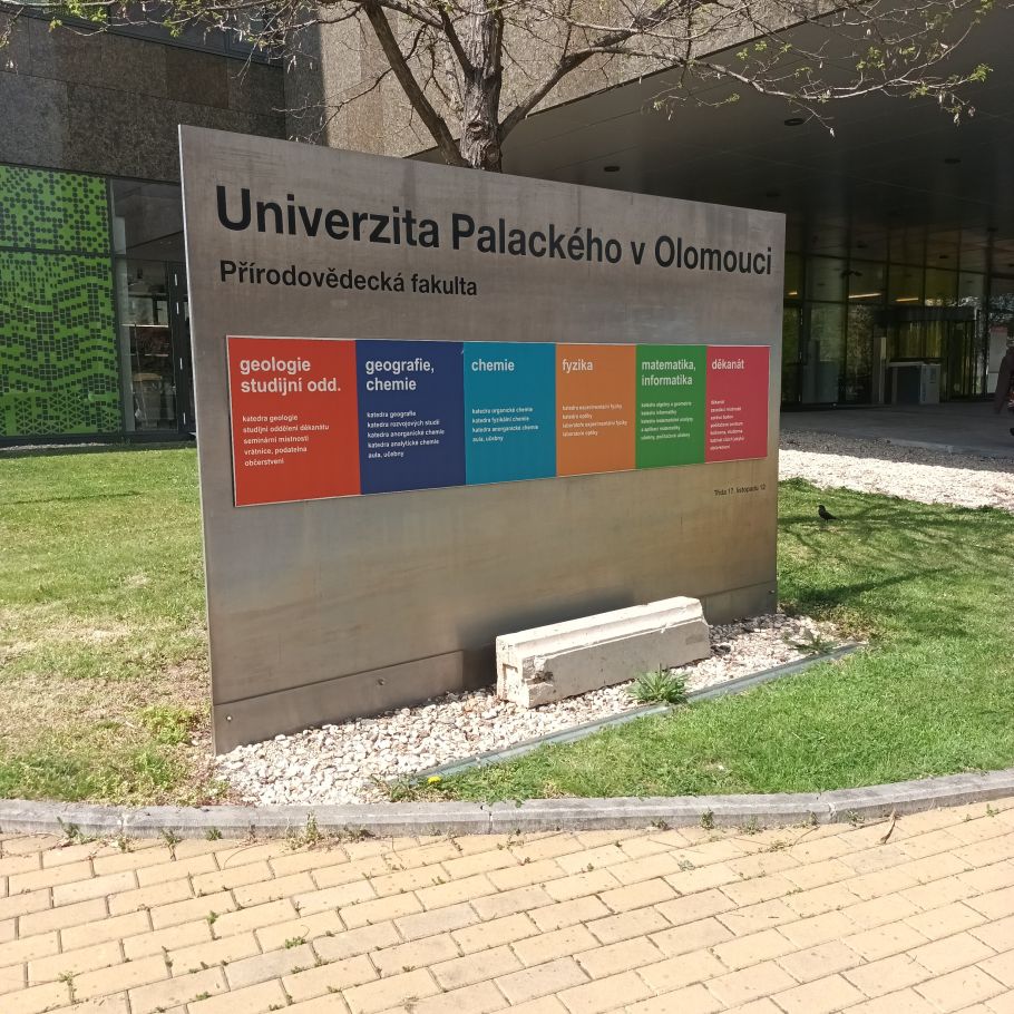 metalowa tablica z nazwą uniwersytetu i nazwami wydziałów - każdym na tle innego koloru