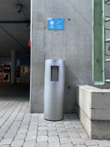 dystrybutor wody stoi przy betonowej ścianie