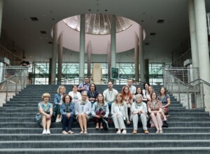 grupa osób siedzi na schodach we wnętrzu