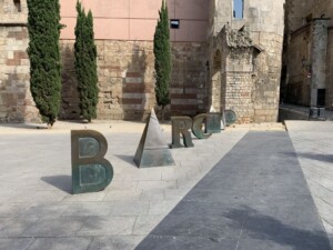 Zdjęcie stylizowanych metalowych liter ustawionych na chodniku, układające się w napis Barcelona