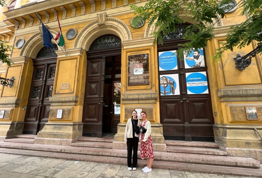 dwie dziewczyny przed żółtą fasadą klasycystycznego budynku