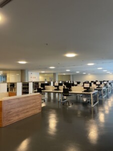 Zdjęcie czytelni bibliotecznej ze stanowiskami komputerowymi.