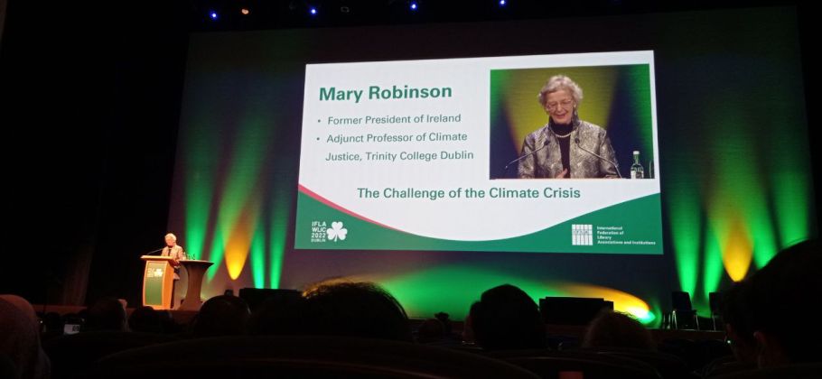 Wystąpienie konferencyjne, na dużej scenie wyświetlony slajd: The Challenge of the Climate Crisis.