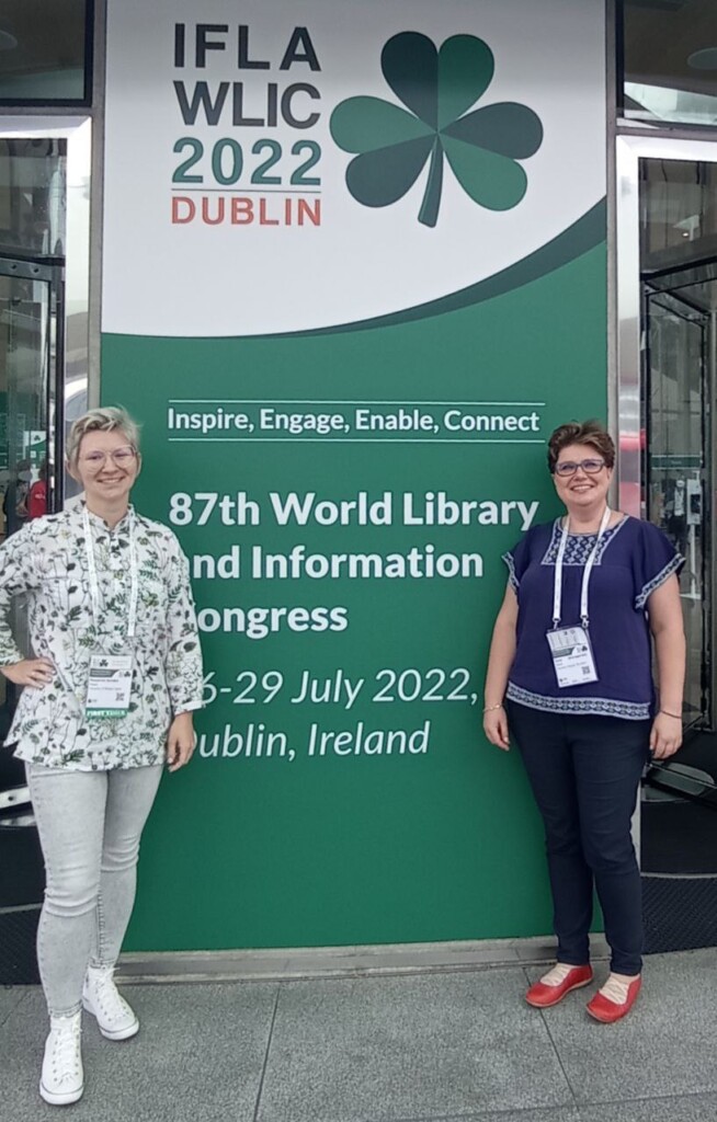 dwie kobiety przed plakatem: 87th World Library and InformationCongress