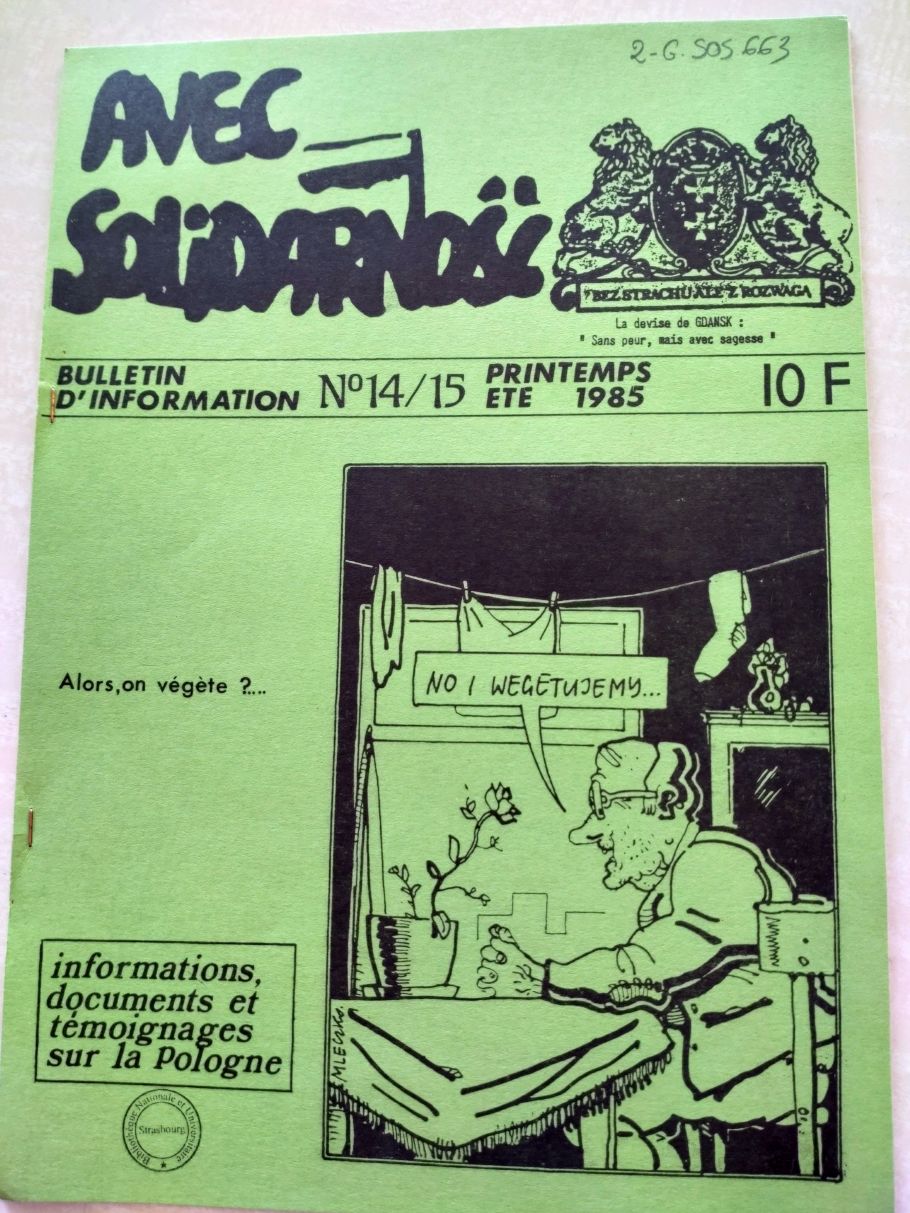 Zdjęcie strony tytułowej gazetki Avec Solidarność, na niej karykaturalny rysunek człowieka mówiącego do rośliny stojącej na stole: No i wegetujemy