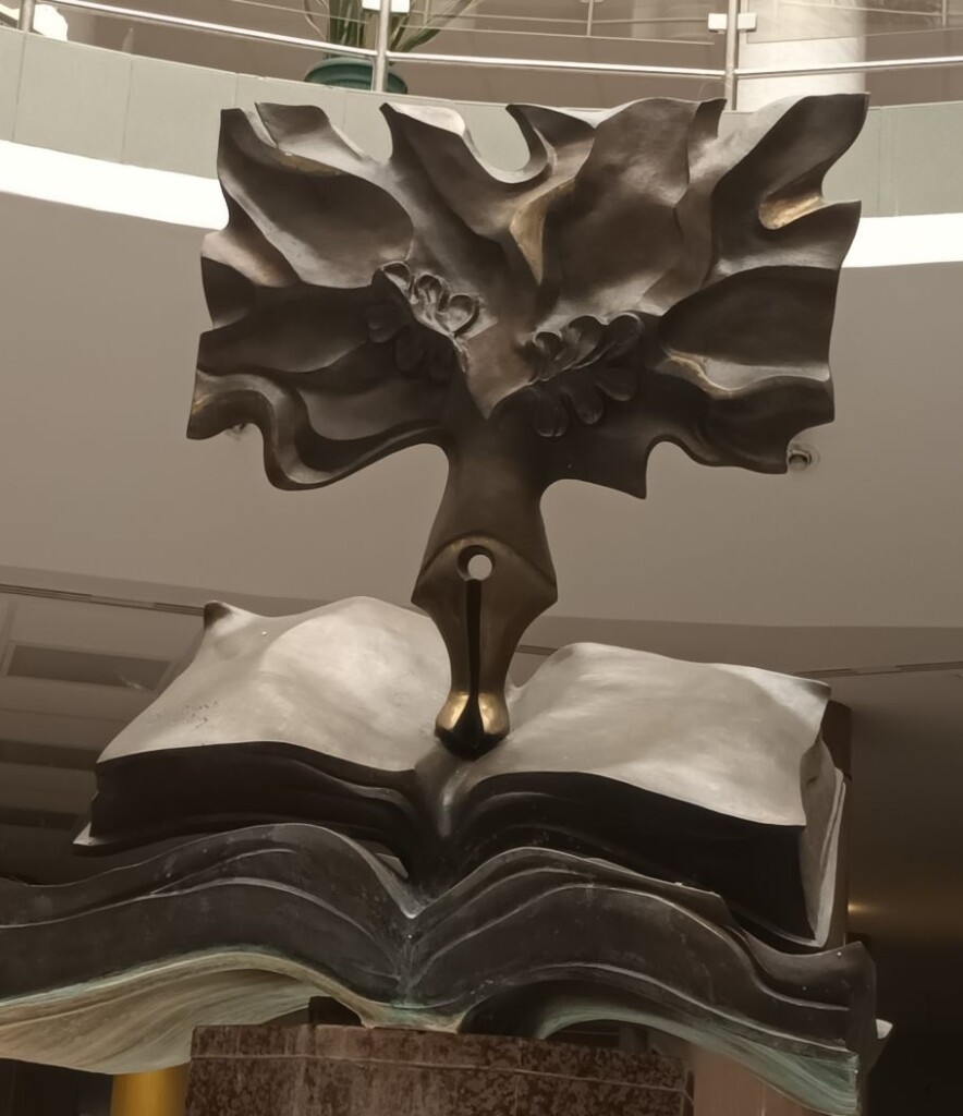 Zdjęcie rzeźby: książka, pióro, liście