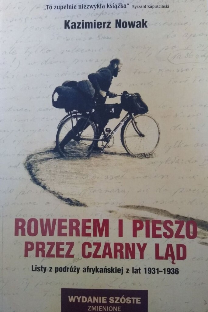 Okładka książki Rowerem i pieszo przez czarny ląd, na niej zdjęcie mężczyzny prowadzącego rower z pakunkiem na bagażniku.