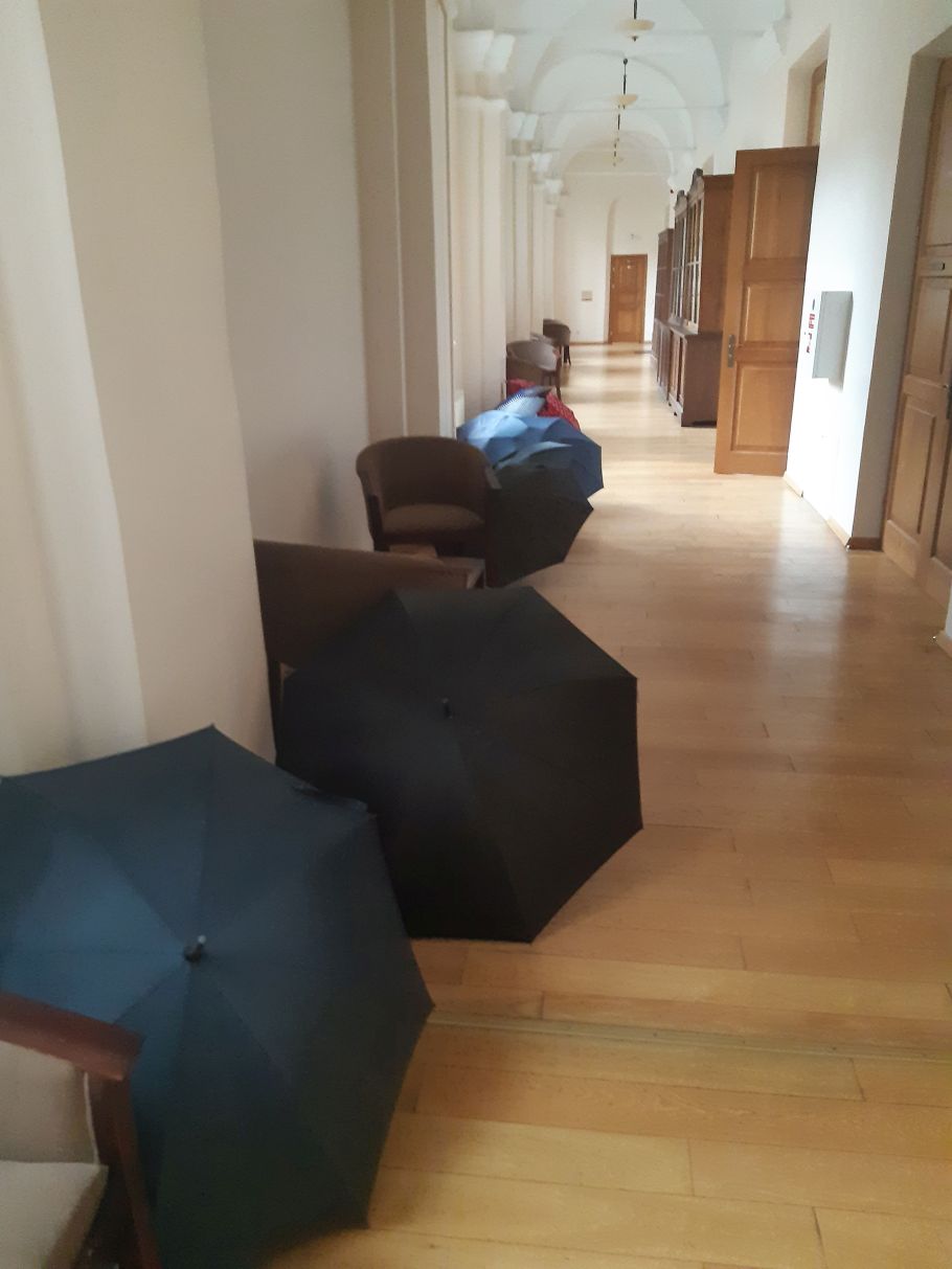 rząd czarnych parasoli rozłożonych w korytarzu