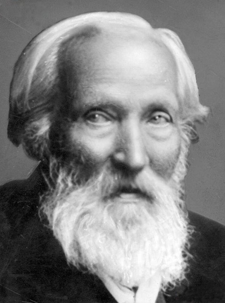 Zdjęcie portretowe starszego mężczyzny z siwymi włosami i brodą.