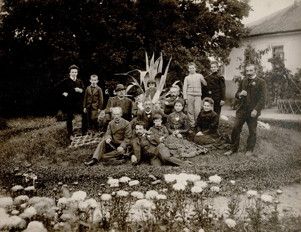 Stare zdjęcie rodzinne (grupowe). Ludzie pozujący w ogrodzie.