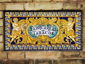 ceramiczna płytka z dwoma puttami trzymającymi napis: Fabrica Real de Tabacos