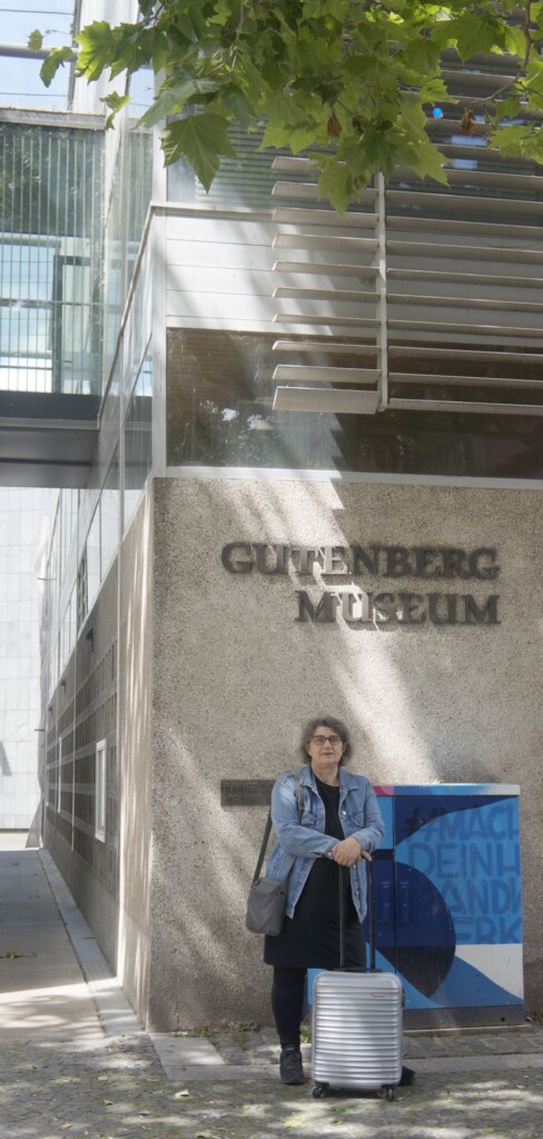 kobieta przed budynkiem podpisanym Gutenberg Museum