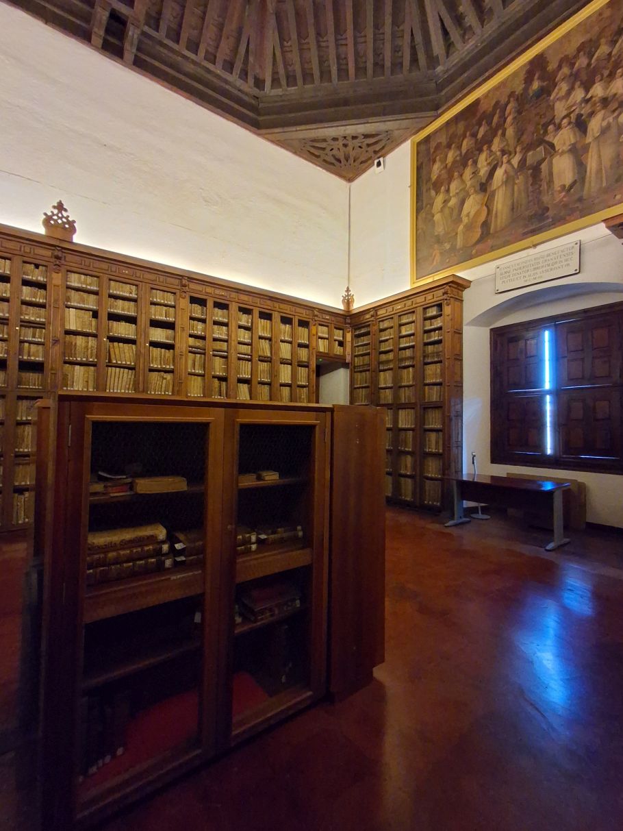 sala z drewnianymi regałami pełnymi starych książek